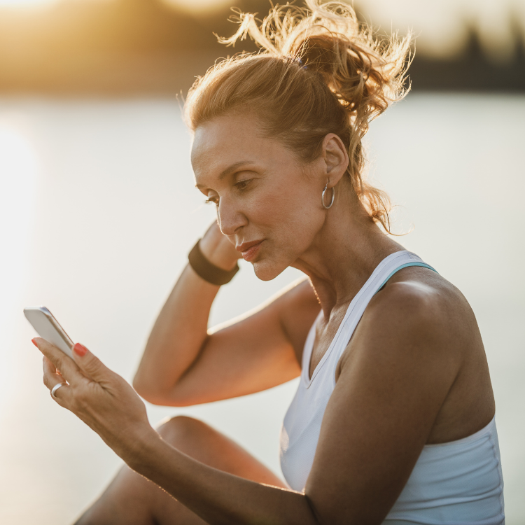 Woman using phone - engaging with wellness technology